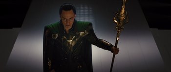 Movie still from “Thor” (2011), directed by Kenneth Branagh – A man dressed as loki holding a golden staff; Medium shot, Low angle