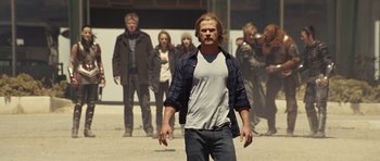 Movie still from “Thor” (2011), directed by Kenneth Branagh – A group of people standing around a man in a white shirt; Medium shot, Low angle
