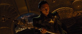 Movie still from “Thor” (2011), directed by Kenneth Branagh – A man in a green jacket holding a sword in a room; Close Up shot, Low angle