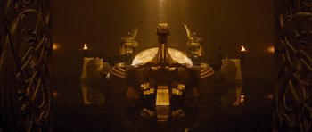Movie still from “Thor” (2011), directed by Kenneth Branagh – A large golden statue sitting on top of a wooden table; Extreme Wide shot, High angle