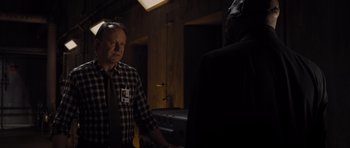 Movie still from “Thor” (2011), directed by Kenneth Branagh – A man wearing a plaid shirt and a neck tie standing next to another man in a room; Medium shot, Over the shoulder angle