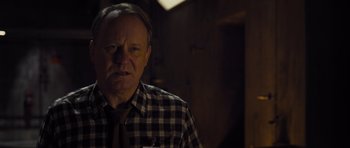 Movie still from “Thor” (2011), directed by Kenneth Branagh – An older man wearing a plaid shirt and a tie; Close Up shot, Over the shoulder angle