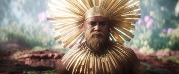 Movie still from “Thor: Love and Thunder” (2022), directed by Taika Waititi – A man with a beard wearing a gold headdress; Close Up shot, Over the shoulder angle