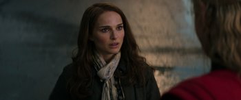 Movie still from “Thor: Love and Thunder” (2022), directed by Taika Waititi – A person with long hair wearing a scarf; Close Up shot, Over the shoulder angle