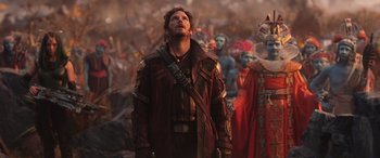 Movie still from “Thor: Love and Thunder” (2022), directed by Taika Waititi – A man standing in front of a group of people; Medium shot, Over the shoulder angle