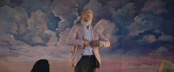 Movie still from “Thor: Love and Thunder” (2022), directed by Taika Waititi – An old man with a long white beard standing in front of a painting; Medium shot, Low angle