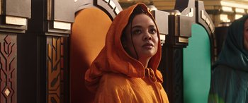 Movie still from “Thor: Love and Thunder” (2022), directed by Taika Waititi – A woman wearing a hooded orange jacket; Close Up shot, Low angle