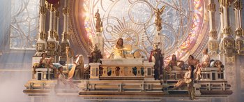 Movie still from “Thor: Love and Thunder” (2022), directed by Taika Waititi – A statue of jesus is sitting on a table; Wide shot, Low angle