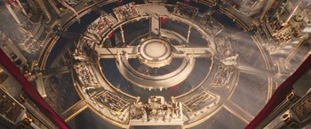 Movie still from “Thor: Love and Thunder” (2022), directed by Taika Waititi – An aerial view of a building that has a clock on it's side; Extreme Wide shot, Overhead angle