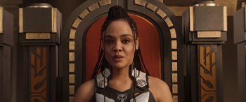 Movie still from “Thor: Love and Thunder” (2022), directed by Taika Waititi – A woman with dreadlocks is standing in front of a chair; Close Up shot, Low angle