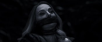 Movie still from “Thor: Love and Thunder” (2022), directed by Taika Waititi – A black and white photo of a woman with a mouth taped to her face; Close Up shot, Low angle