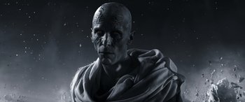 Movie still from “Thor: Love and Thunder” (2022), directed by Taika Waititi – A man with a bald head wearing a white robe; Close Up shot, Low angle