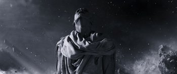 Movie still from “Thor: Love and Thunder” (2022), directed by Taika Waititi – A black and white photo of a statue in the dark; Medium shot, Low angle