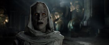 Movie still from “Thor: Love and Thunder” (2022), directed by Taika Waititi – An evil looking person wearing a white robe; Close Up shot, Over the shoulder angle