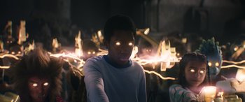 Movie still from “Thor: Love and Thunder” (2022), directed by Taika Waititi – A young man with glowing eyes in front of a bunch of lights; Medium shot, Low angle