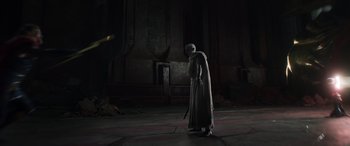 Movie still from “Thor: Love and Thunder” (2022), directed by Taika Waititi – A man in a robe and a hood holding a sword; Wide shot, Low angle