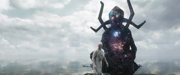 Movie still from “Thor: Love and Thunder” (2022), directed by Taika Waititi – A man standing in front of an alien creature in the water; Wide shot, Overhead angle