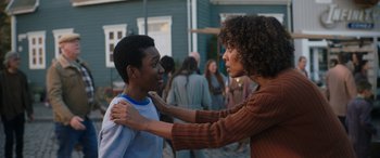 Movie still from “Thor: Love and Thunder” (2022), directed by Taika Waititi – A woman helping a young boy with his shirt off; Medium shot, Over the shoulder angle