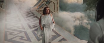Movie still from “Thor: Love and Thunder” (2022), directed by Taika Waititi – A woman in a white dress standing in front of clouds; Medium shot, High angle