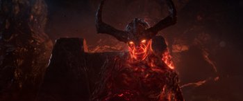 Movie still from “Thor: Ragnarok” (2017), directed by Taika Waititi – A demon with horns is sitting in the middle of a fire; Close Up shot, High angle