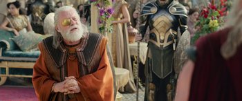 Movie still from “Thor: Ragnarok” (2017), directed by Taika Waititi – A man with a long white beard standing in front of other people; Medium shot, Over the shoulder angle