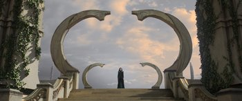 Movie still from “Thor: Ragnarok” (2017), directed by Taika Waititi – A person standing on steps in front of a sky background; Extreme Wide shot, Low angle