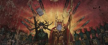 Movie still from “Thor: Ragnarok” (2017), directed by Taika Waititi – A painting of a woman and a man holding a hammer; Medium shot, Low angle