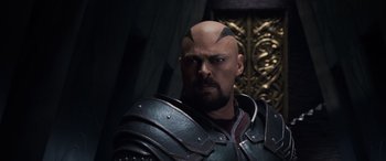 Movie still from “Thor: Ragnarok” (2017), directed by Taika Waititi – A man with a shaved head and a beard; Close Up shot, Over the shoulder angle