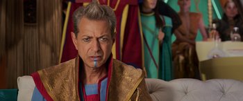 Movie still from “Thor: Ragnarok” (2017), directed by Taika Waititi – An older man wearing a gold robe and a red and blue cape; Close Up shot, Over the shoulder angle