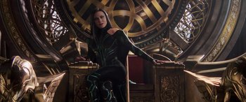 Movie still from “Thor: Ragnarok” (2017), directed by Taika Waititi – A woman sitting on top of a chair in a room; Medium shot, Low angle