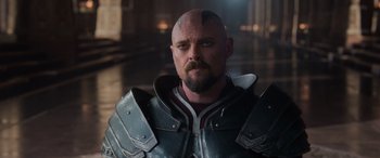 Movie still from “Thor: Ragnarok” (2017), directed by Taika Waititi – A man with a bald head wearing armor; Close Up shot, Over the shoulder angle