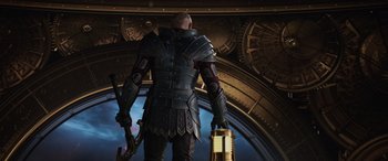 Movie still from “Thor: Ragnarok” (2017), directed by Taika Waititi – A man in a leather armor holding a sword and looking out a window; Medium shot, Low angle