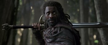 Movie still from “Thor: Ragnarok” (2017), directed by Taika Waititi – A man with a beard holding an axe in his hand; Close Up shot, Over the shoulder angle