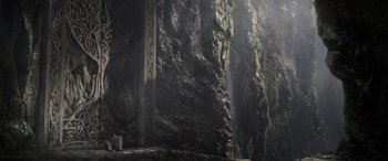 Movie still from “Thor: Ragnarok” (2017), directed by Taika Waititi – A stone wall with a large rock wall in the background; Extreme Wide shot, High angle