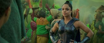 Movie still from “Thor: Ragnarok” (2017), directed by Taika Waititi – A woman standing in front of other people; Close Up shot, Over the shoulder angle