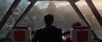 Movie still from “Thor: Ragnarok” (2017), directed by Taika Waititi – A man looking out of a window at a city skyline; Extreme Wide shot, Low angle