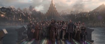 Movie still from “Thor: Ragnarok” (2017), directed by Taika Waititi – A group of people standing in front of a building; Wide shot, Low angle