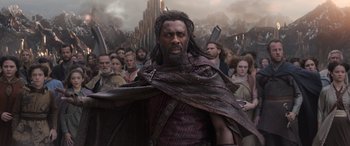 Movie still from “Thor: Ragnarok” (2017), directed by Taika Waititi – A large group of people are gathered around a man; Medium shot, Low angle