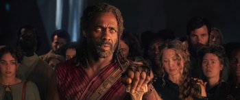 Movie still from “Thor: Ragnarok” (2017), directed by Taika Waititi – A man with dreadlocks is holding something in his hand; Close Up shot, Low angle