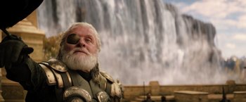 Movie still from “Thor: The Dark World” (2013), directed by Alan Taylor – An old man with a beard and eye patch is standing in front of a waterfall; Close Up shot, Low angle