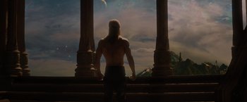 Movie still from “Thor: The Dark World” (2013), directed by Alan Taylor – A man with long blonde hair standing in front of pillars; Medium shot, Low angle