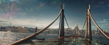 Movie still from “Thor: The Dark World” (2013), directed by Alan Taylor – A man standing on a pier next to the ocean; Extreme Wide shot, High angle