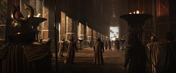 Movie still from “Thor: The Dark World” (2013), directed by Alan Taylor – A group of people dressed in costumes in a building; Extreme Wide shot, Over the shoulder angle
