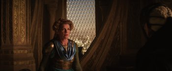 Movie still from “Thor: The Dark World” (2013), directed by Alan Taylor – A woman in a blue and gold dress standing in front of a window; Medium shot, Low angle