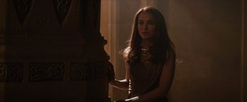 Movie still from “Thor: The Dark World” (2013), directed by Alan Taylor – A beautiful young woman standing next to a pillar; Medium shot, Over the shoulder angle