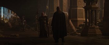 Movie still from “Thor: The Dark World” (2013), directed by Alan Taylor – Two men in medieval garb stand in the dark; Medium shot, Over the shoulder angle