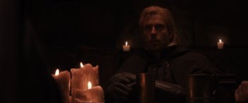 Movie still from “Thor: The Dark World” (2013), directed by Alan Taylor – A man sitting in front of some lit candles; Medium shot, Over the shoulder angle