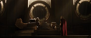 Movie still from “Thor: The Dark World” (2013), directed by Alan Taylor – A man dressed as thor standing in front of a large circular window; Wide shot, Over the shoulder angle