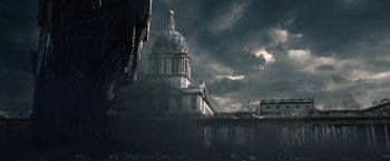 Movie still from “Thor: The Dark World” (2013), directed by Alan Taylor – A large building with a golden dome on top of it under a cloudy sky; Extreme Wide shot, Low angle