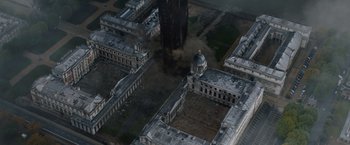 Movie still from “Thor: The Dark World” (2013), directed by Alan Taylor – An aerial view of an old building with smoke billowing from it; Extreme Wide shot, Overhead angle